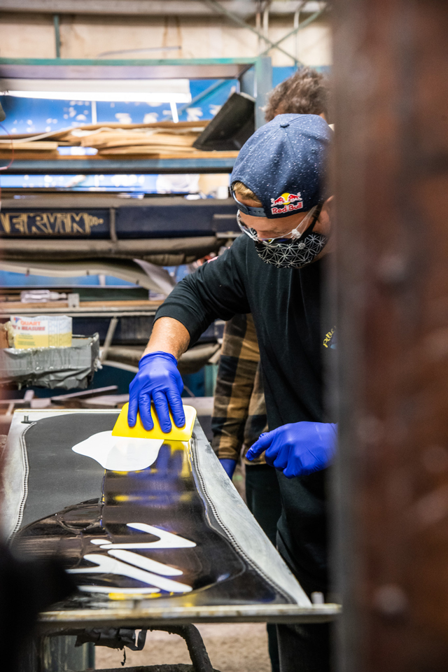 Travis Rice spreading resin on snowboard base