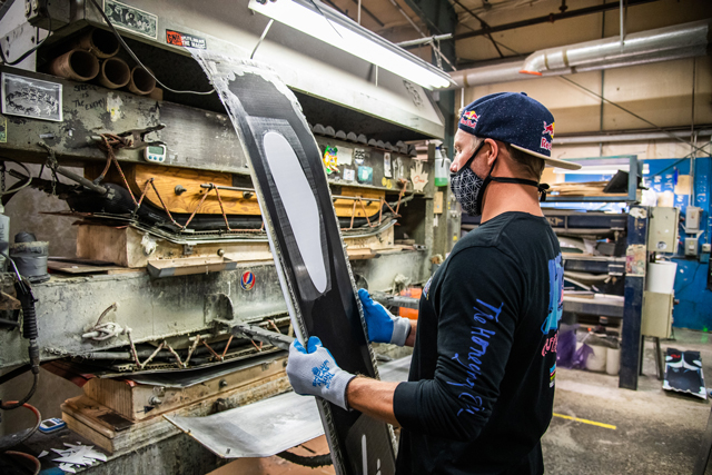 Travis Rice looking at the Orca Snowboard Tail