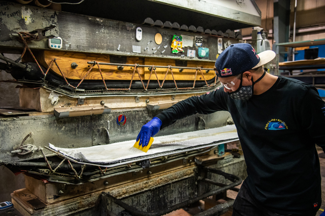 Travis Rice spreading resin on fiberglass for Orca Snowboard